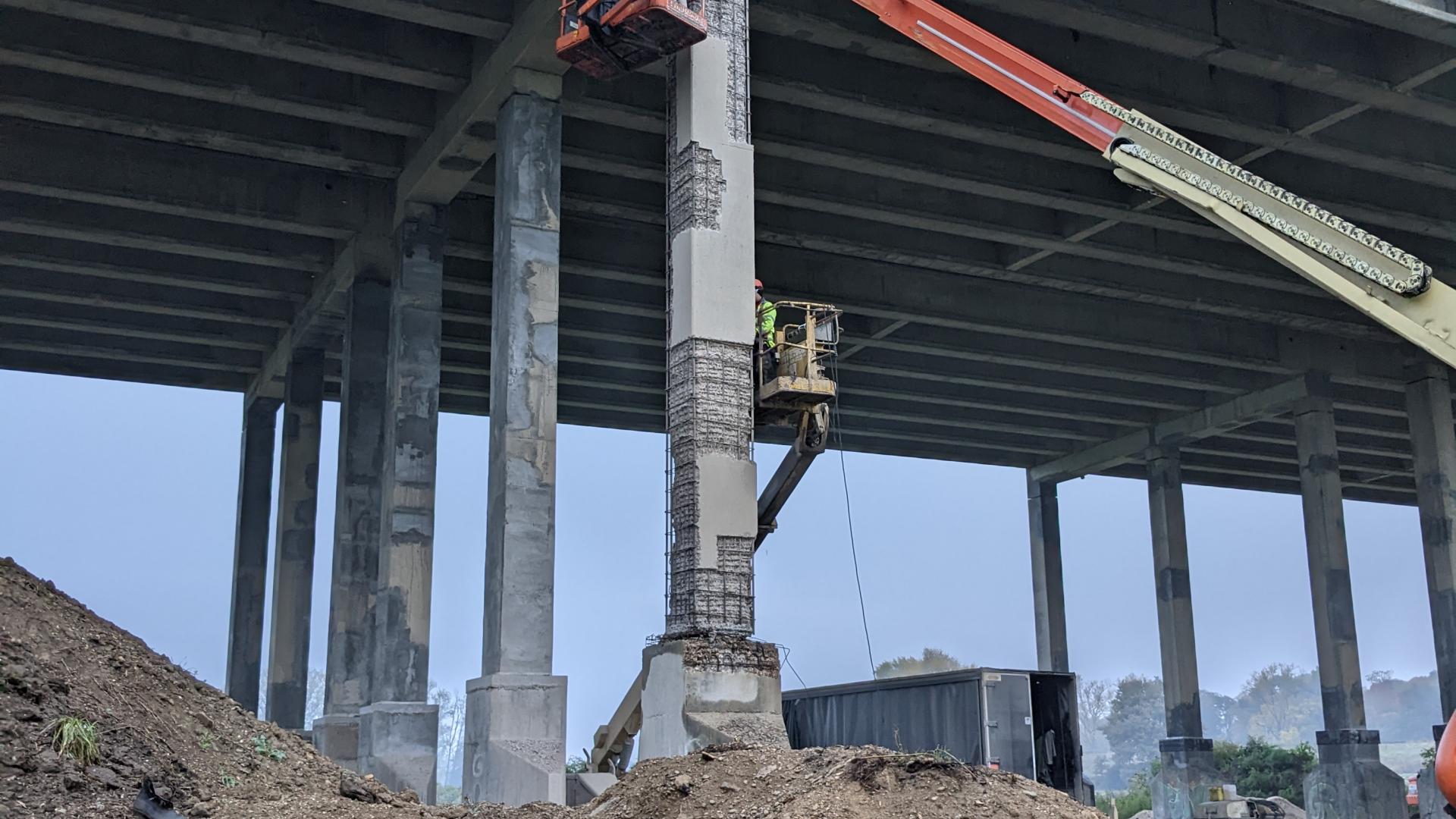 De aannemer herstelt het beton van de pijlers van het viaduct.